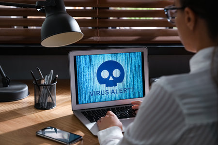 Woman using laptop with warning about virus attack at workplace, closeup