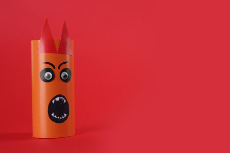 Funny orange monster on red background, space for text. halloween decorationの写真素材