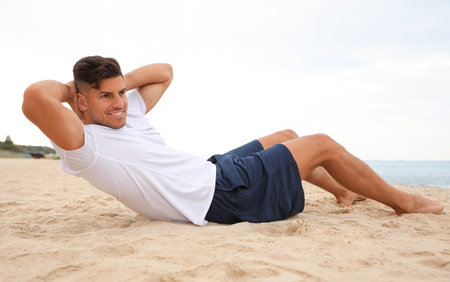 Muscular man doing exercise on the beach. body trainingの写真素材