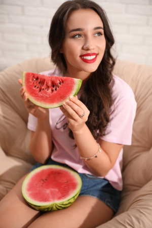Beautiful young woman with watermelon at homeの写真素材
