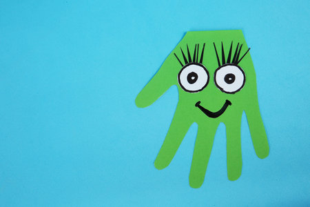 Funny green hand shaped monster on light blue background, top view with space for text. halloween decorationの写真素材