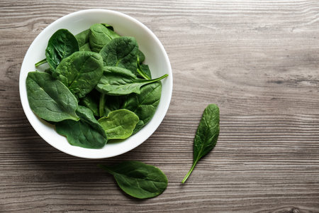 Fresh healthy green spinach leaves on wooden table, flat lay. Space for textの写真素材