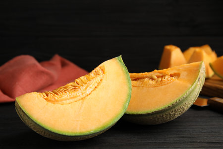 Tasty fresh cut melon on black wooden table, closeupの写真素材
