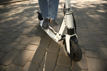 Woman riding electric kick scooter outdoors, closeup