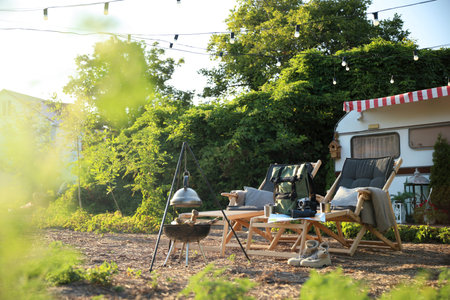 Deck chairs and travel accessories near modern motorhome. camping season