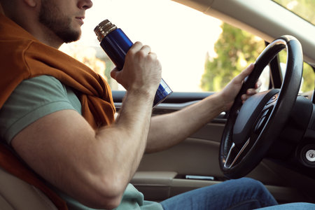 Man with thermo driving car, closeup view