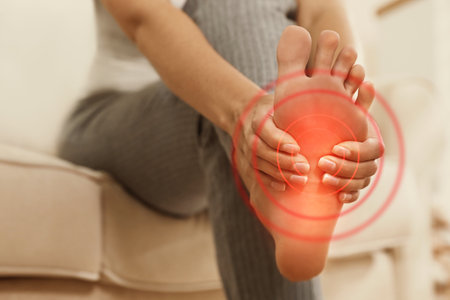 Young woman suffering from foot pain indoors, closeupの写真素材