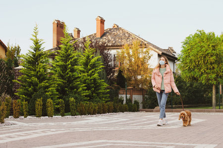 Woman in protective mask with English Cocker Spaniel outdoors.の写真素材