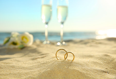 Beautiful gold wedding rings on sandy beachの写真素材