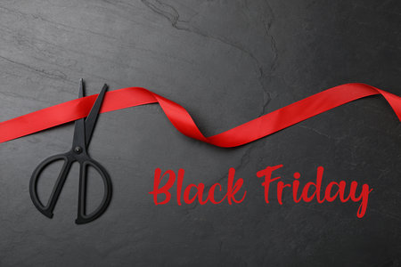 Phrase Black Friday, ribbon and scissors on dark background, flat layの写真素材