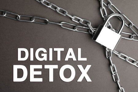 Digital detox concept. Steel padlock, chains and text on gray background, flat lay
