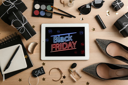 Flat lay composition with tablet, gifts and accessories on wooden background. black friday saleの写真素材
