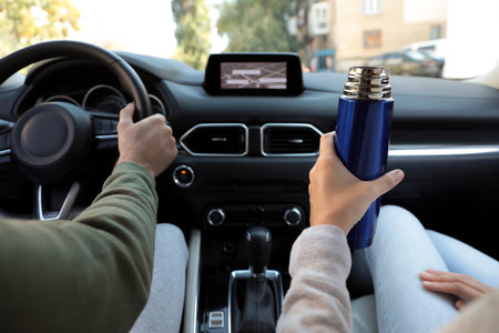 Couple with thermo in car, closeup view