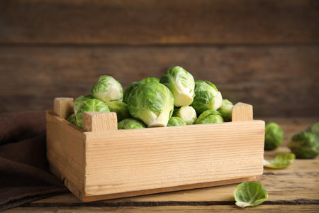 Crate with fresh Brussels sprouts on wooden table, closeupの写真素材