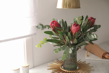 Bouquet with beautiful protea flowers on countertop in kitchen. interior design