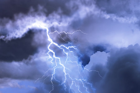 Lightning in dark cloudy sky during thunderstorm