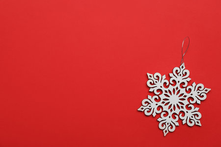 Beautiful decorative snowflake on red background, top view. Space for textの写真素材