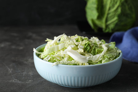 Cut fresh savoy cabbage in bowl on gray table, closeupの写真素材