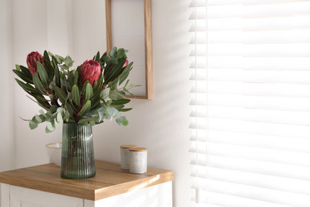 Vase with beautiful Protea flowers on table indoorsの写真素材