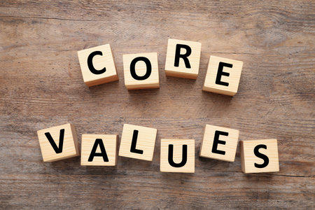 Cubes with phrase CORE VALUES on wooden background, flat lay