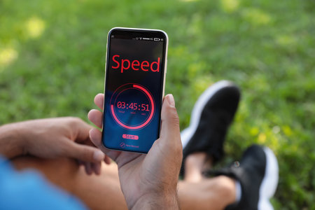 Man using fitness app on smartphone outdoors, closeup