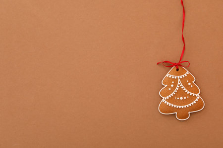 Christmas tree shaped cookie on brown background, top view. Space for textの写真素材