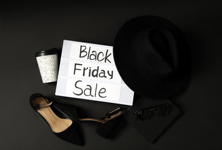 Flat lay composition with women's shoes, hat and phrase Black Friday Sale on dark backgroundの写真素材