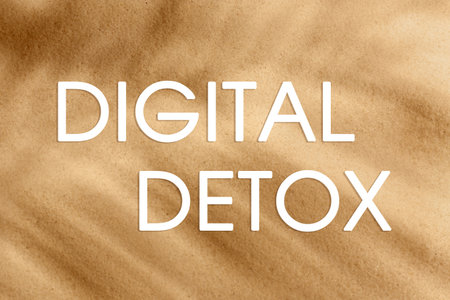 Text Digital Detox and golden beach sand with tropical palm leaf shadow on background, top viewの写真素材