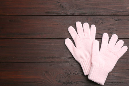 Stylish pink gloves on wooden background, flat lay. Space for textの写真素材