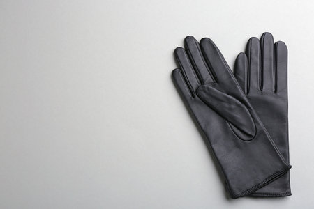Pair of stylish leather gloves on light grey background, flat lay. Space for textの写真素材