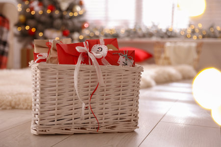 Basket full of gifts in paper bags for Christmas advent calendar at home, space for textの写真素材