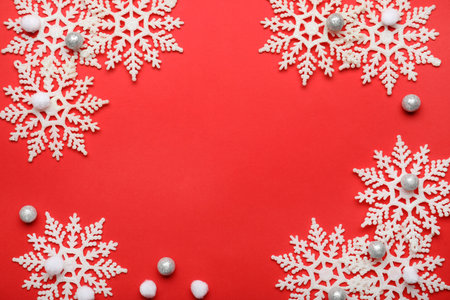 Beautiful decorative snowflakes on red background, flat lay. Space for textの写真素材