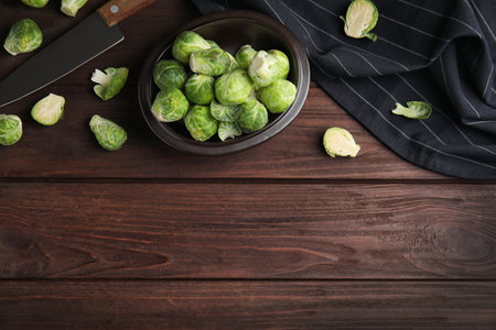 Fresh Brussels sprouts on brown wooden table, flat lay. Space for textの写真素材