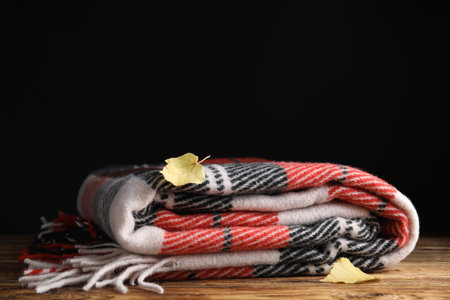 Checkered plaid and dry leaves on wooden tableの写真素材