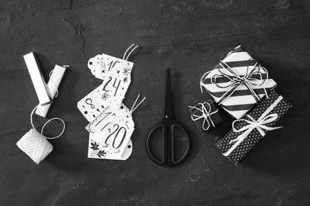 Flat lay composition with gift boxes on black table. Creating an advent calendarの写真素材