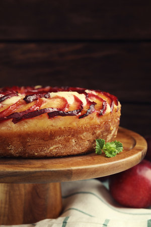 Delicious pie with plums on wooden cake stand, closeupの写真素材