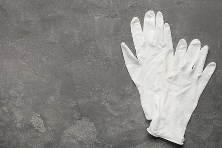 Pair of medical gloves on gray background, flat lay. Space for text