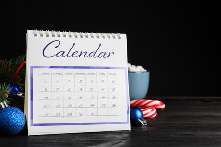 Flip calendar and Christmas decor on black wooden table. holiday count down
