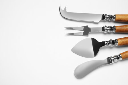 Cheese knives and forks on white background, top viewの写真素材