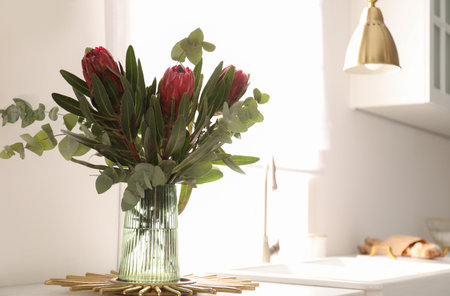 Bouquet with beautiful protea flowers on countertop in kitchen, space for text. Interior designの写真素材