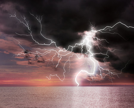 Dark cloudy sky with lightning striking sea. picturesque thunderstormの写真素材