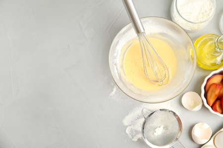 Dough and ingredients for cake on light gray table, flat lay. Space for text