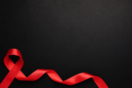 Top view of red ribbon on black background, space for text. AIDS disease awarenessの写真素材