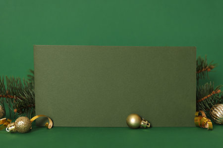 Blank greeting card and Christmas decor on green background, space for textの写真素材
