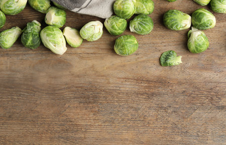Fresh Brussels sprouts on wooden table, flat lay. Space for textの写真素材