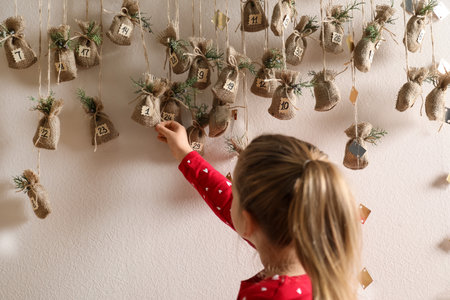 Little girl taking gift from New Year advent calendar indoorsの写真素材