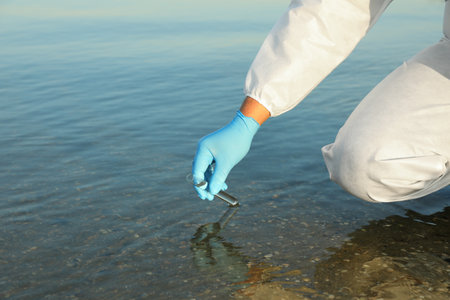 Scientist with test tube taking sample from river for analysis, closeupの写真素材