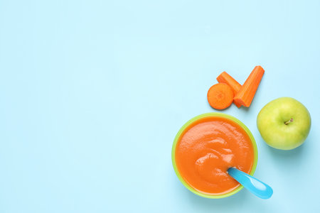 Healthy baby food and ingredients on light blue background, flat lay. Space for textの写真素材