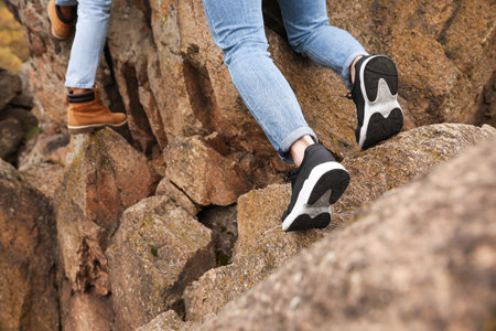 Hikers climbing up mountain, closeup of legs