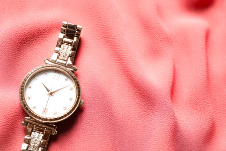 Luxury wrist watch on pink fabric, top view. Space for textの写真素材